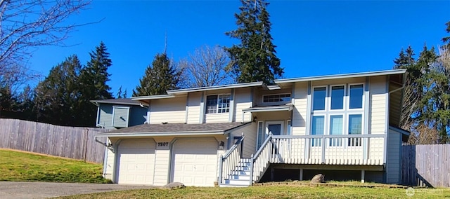 view of front of house with stairway, an attached garage, driveway, and fence