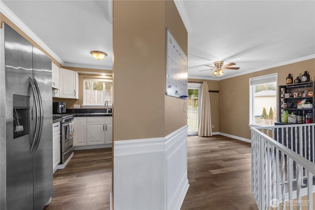 kitchen featuring a sink, dark countertops, appliances with stainless steel finishes, and ornamental molding