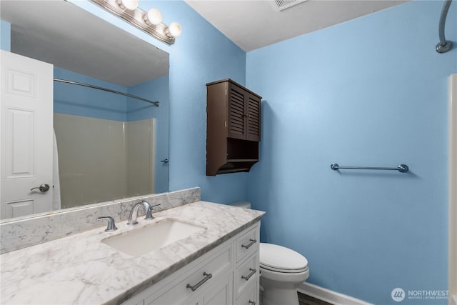 bathroom featuring baseboards, toilet, vanity, and walk in shower