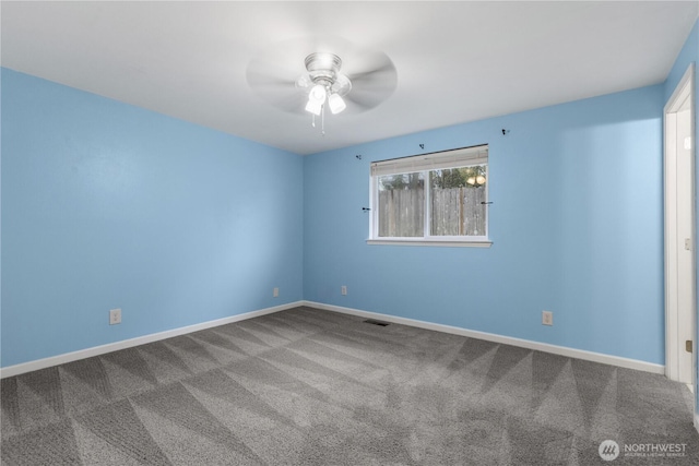 carpeted spare room with visible vents, baseboards, and ceiling fan