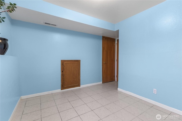 unfurnished room featuring light tile patterned floors, visible vents, and baseboards