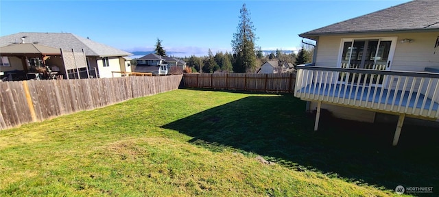 view of yard featuring a residential view, a deck, and fence