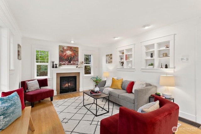 3657 23rd Ave W, Seattle, WA 98199 - living area featuring crown molding, a fireplace, light wood finished floors, and built in features