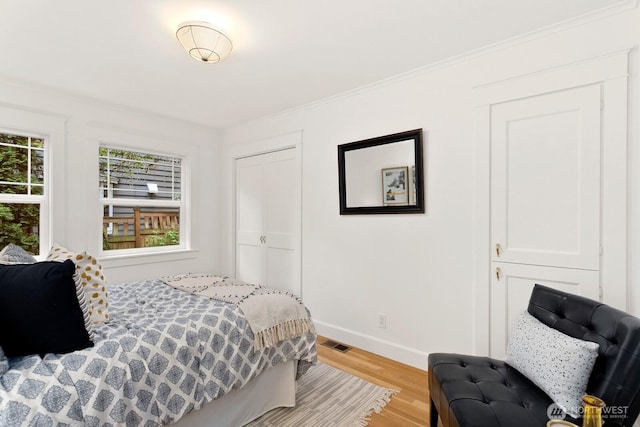 3657 23rd Ave W, Seattle, WA 98199 - bedroom featuring light wood-style floors, a closet, and ornamental molding