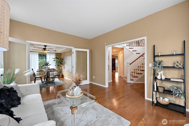 living area featuring stairs, baseboards, and wood finished floors