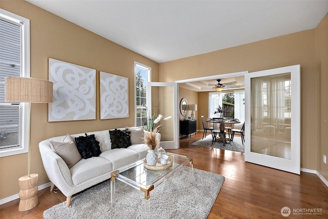 living area featuring baseboards, wood finished floors, and french doors