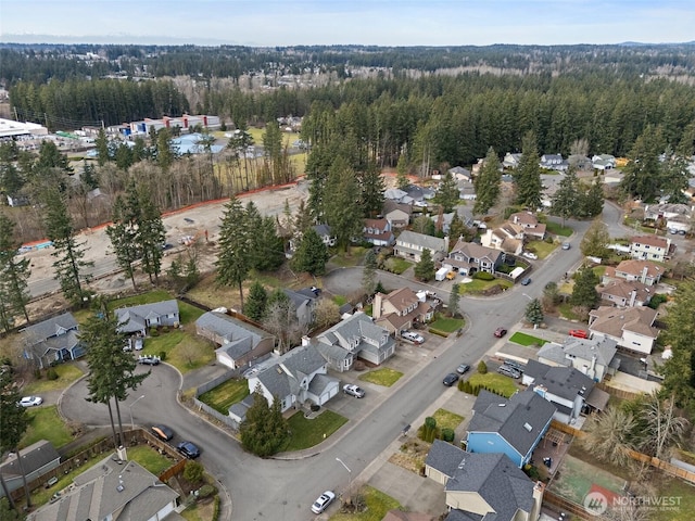 drone / aerial view featuring a residential view and a view of trees