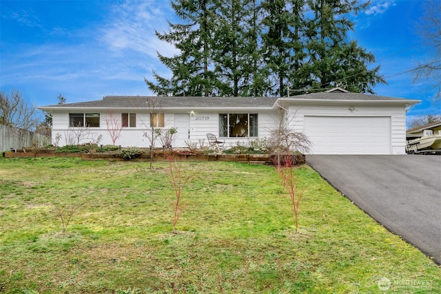 ranch-style house with an attached garage, driveway, and a front yard