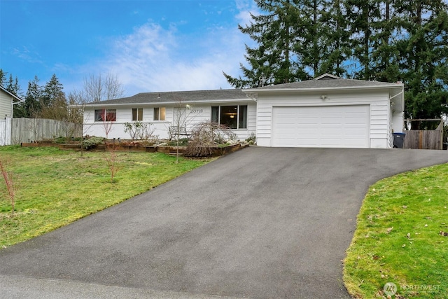 single story home featuring driveway, a garage, fence, and a front yard