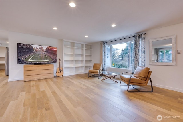 living area with baseboards, light wood finished floors, and recessed lighting