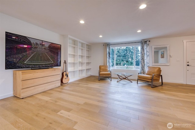 living area with baseboards, light wood-type flooring, and recessed lighting