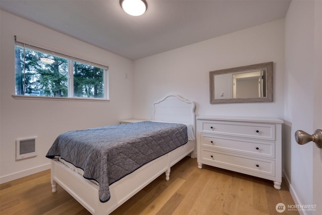 bedroom with visible vents, light wood-style flooring, and baseboards