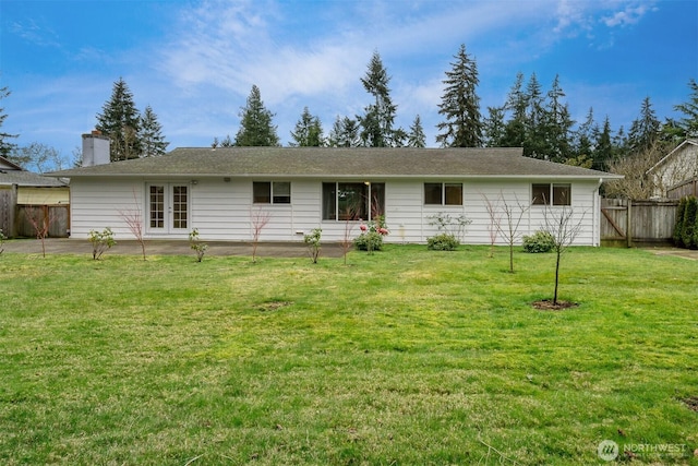 back of property featuring a yard, a chimney, fence, and french doors