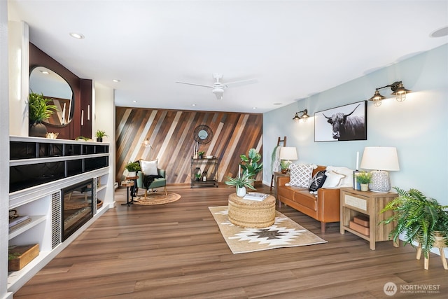 living room featuring recessed lighting, an accent wall, ceiling fan, wood finished floors, and a tile fireplace