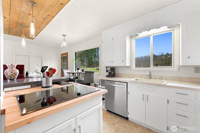 kitchen featuring a sink, white cabinets, wooden counters, dishwasher, and decorative light fixtures