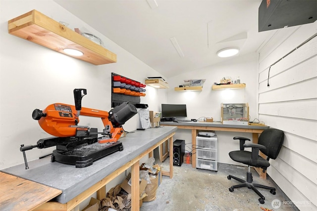 office featuring concrete floors, vaulted ceiling, and a workshop area