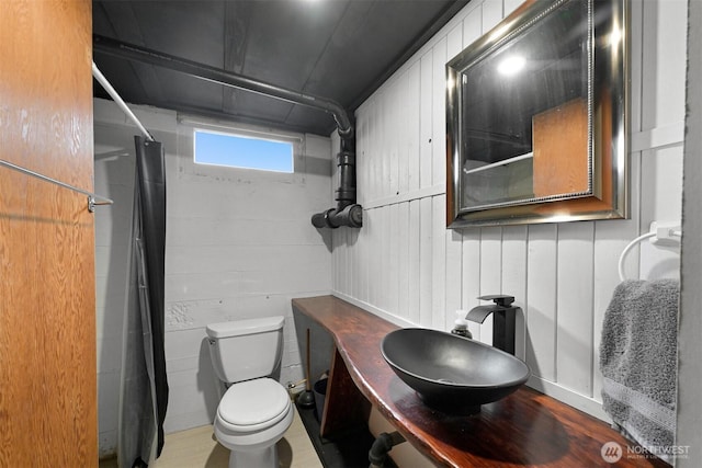 bathroom with curtained shower, a sink, and toilet