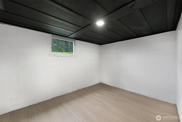 basement featuring concrete block wall and light wood-style flooring