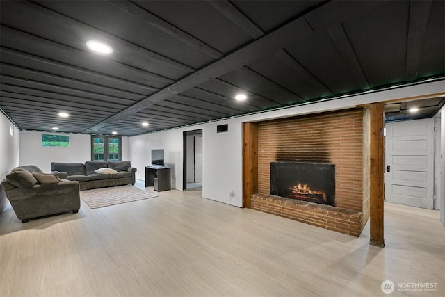 living area with light wood-type flooring and a brick fireplace