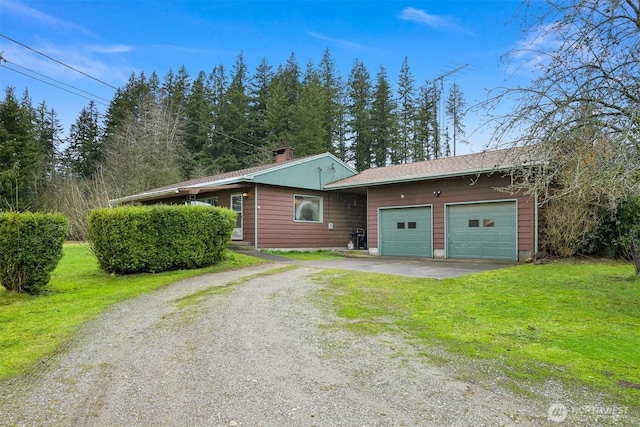 view of front facade featuring a garage, driveway, a chimney, and a front lawn