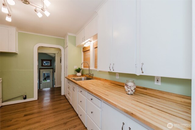 kitchen featuring crown molding, white cabinetry, and a sink