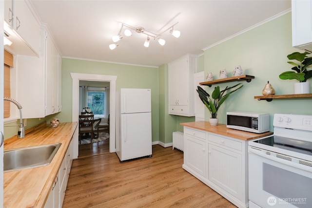 kitchen featuring butcher block countertops, white appliances, a sink, ornamental molding, and radiator heating unit