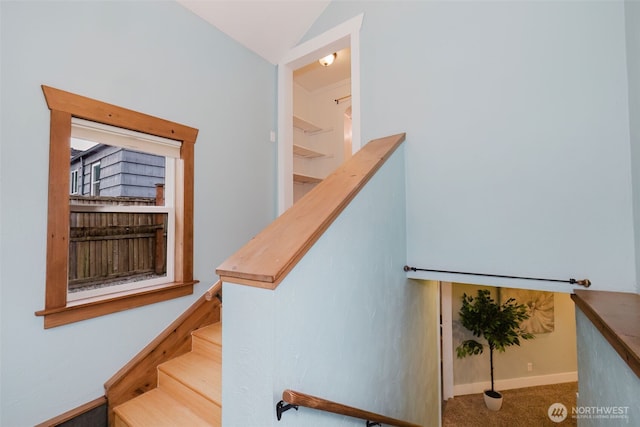 stairs featuring vaulted ceiling, carpet floors, and baseboards