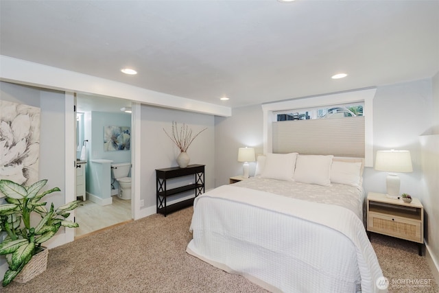 bedroom featuring recessed lighting, light colored carpet, baseboards, and ensuite bathroom