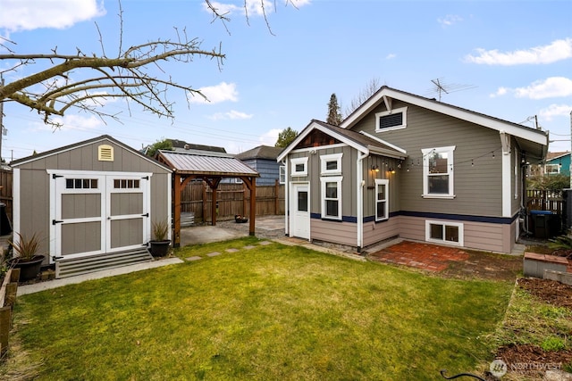 back of house featuring an outbuilding, a fenced backyard, a gazebo, a lawn, and a storage unit