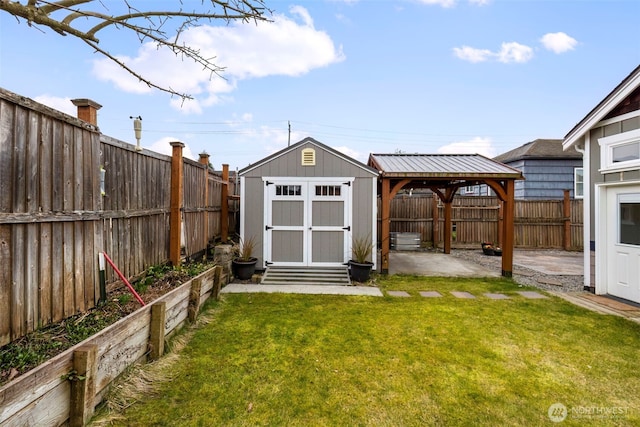 view of yard with a storage shed, a gazebo, a fenced backyard, and a garden