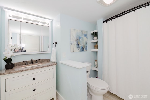 bathroom with curtained shower, vanity, and toilet