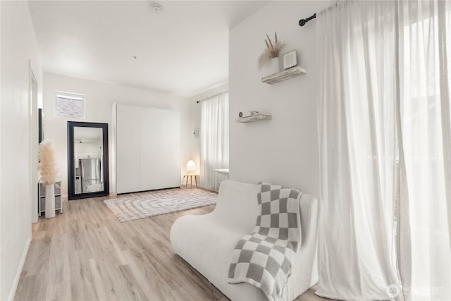 living area featuring light wood-style flooring and baseboards