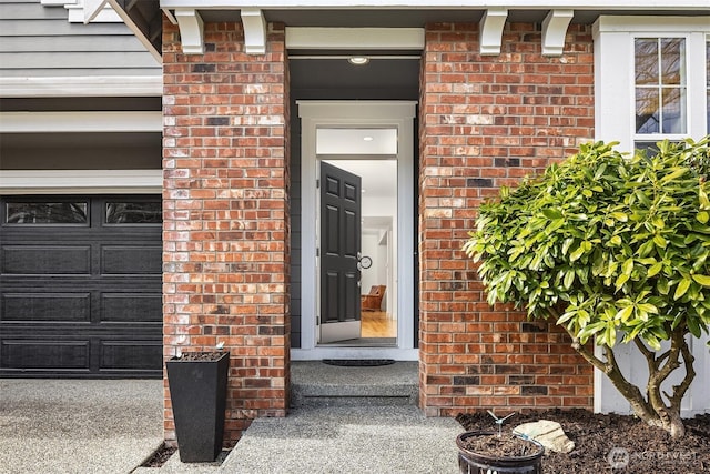 entrance to property featuring brick siding and an attached garage