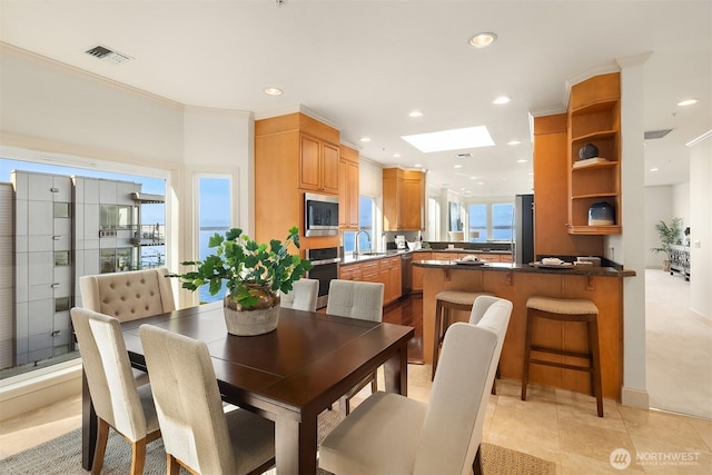 dining space with recessed lighting, crown molding, visible vents, and a skylight