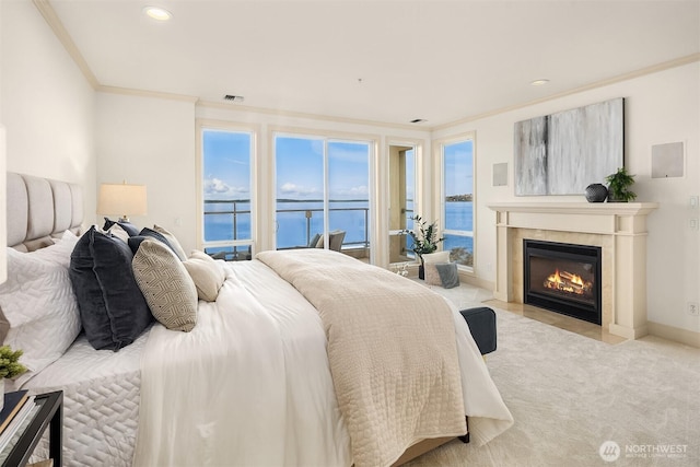 bedroom featuring a water view, access to exterior, crown molding, a fireplace, and carpet flooring