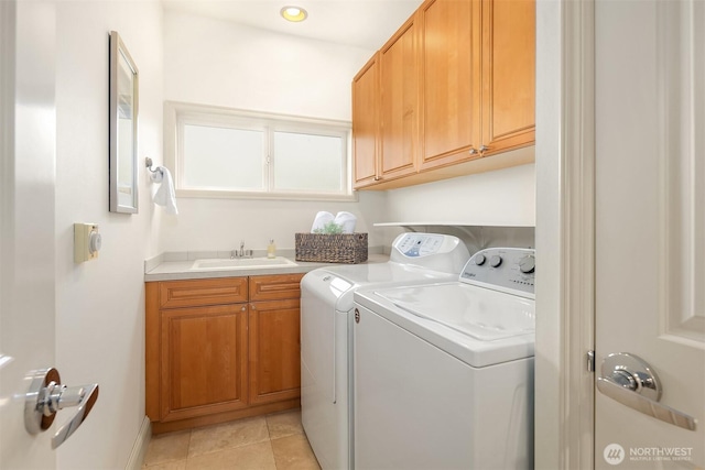 laundry area with independent washer and dryer, a sink, light tile patterned floors, and cabinet space