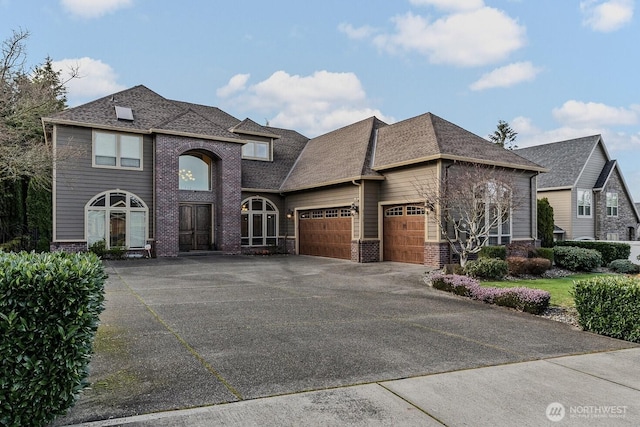 view of front of house with a garage, driveway, roof with shingles, and brick siding