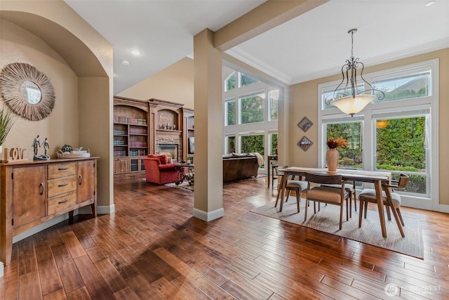 dining area featuring a towering ceiling, dark wood-style floors, and baseboards