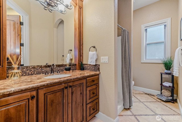 full bath featuring tasteful backsplash, toilet, vanity, and baseboards