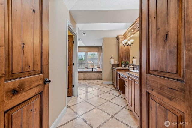 full bathroom with vanity, baseboards, and a bath