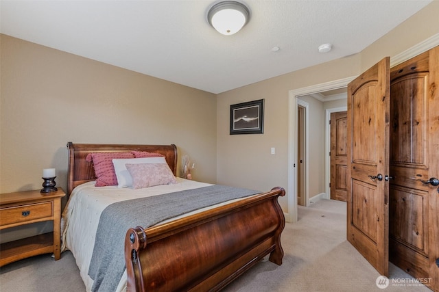 bedroom featuring light carpet and baseboards