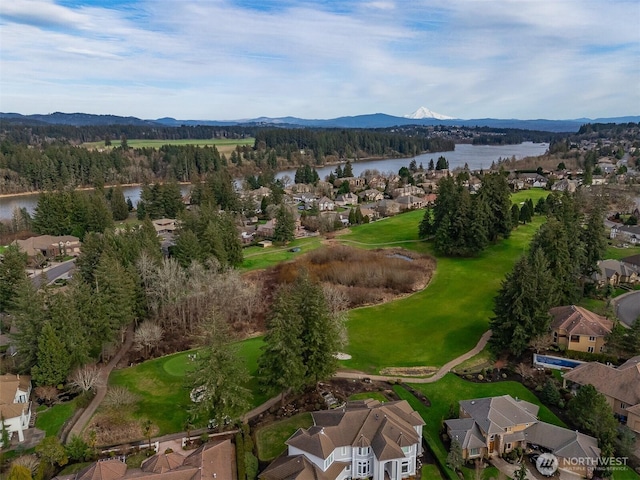 drone / aerial view with a residential view, a wooded view, and a water and mountain view