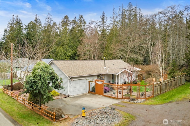 view of front facade featuring a gate, driveway, roof with shingles, a garage, and a fenced front yard