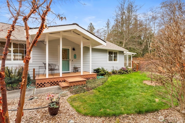 view of front of house with a front yard, a porch, and a shingled roof