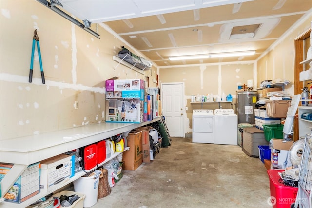 garage with washer and dryer, a workshop area, and water heater