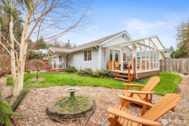 back of house featuring a lawn and fence