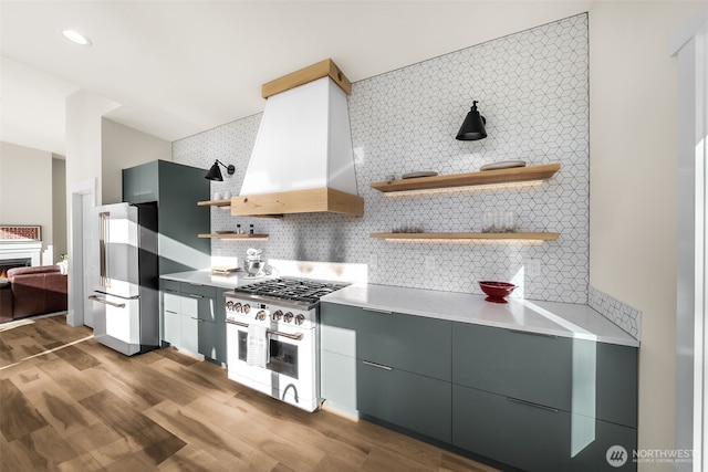 kitchen with open shelves, stainless steel appliances, backsplash, wood finished floors, and extractor fan