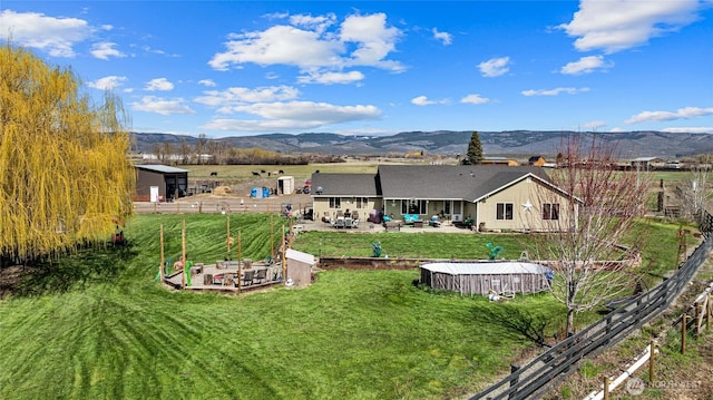 10893 Brick Mill Rd, Ellensburg, WA 98926 - back of property with a patio, a mountain view, an outbuilding, fence, and a lawn