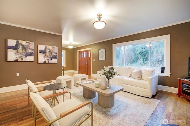 living room with hardwood / wood-style flooring, crown molding, and baseboards