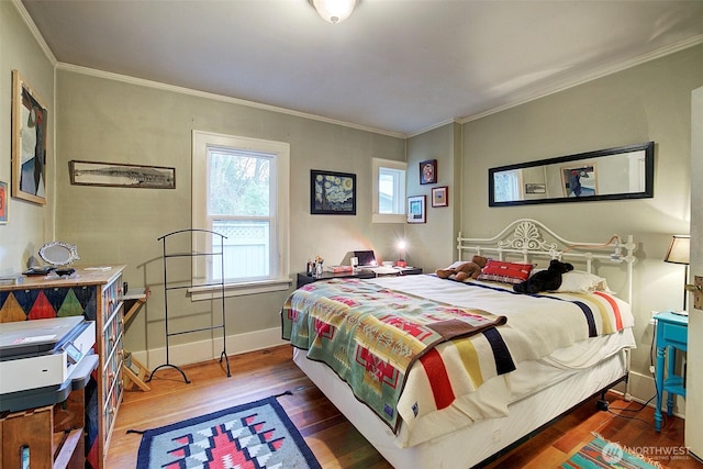 bedroom featuring wood finished floors, baseboards, and ornamental molding